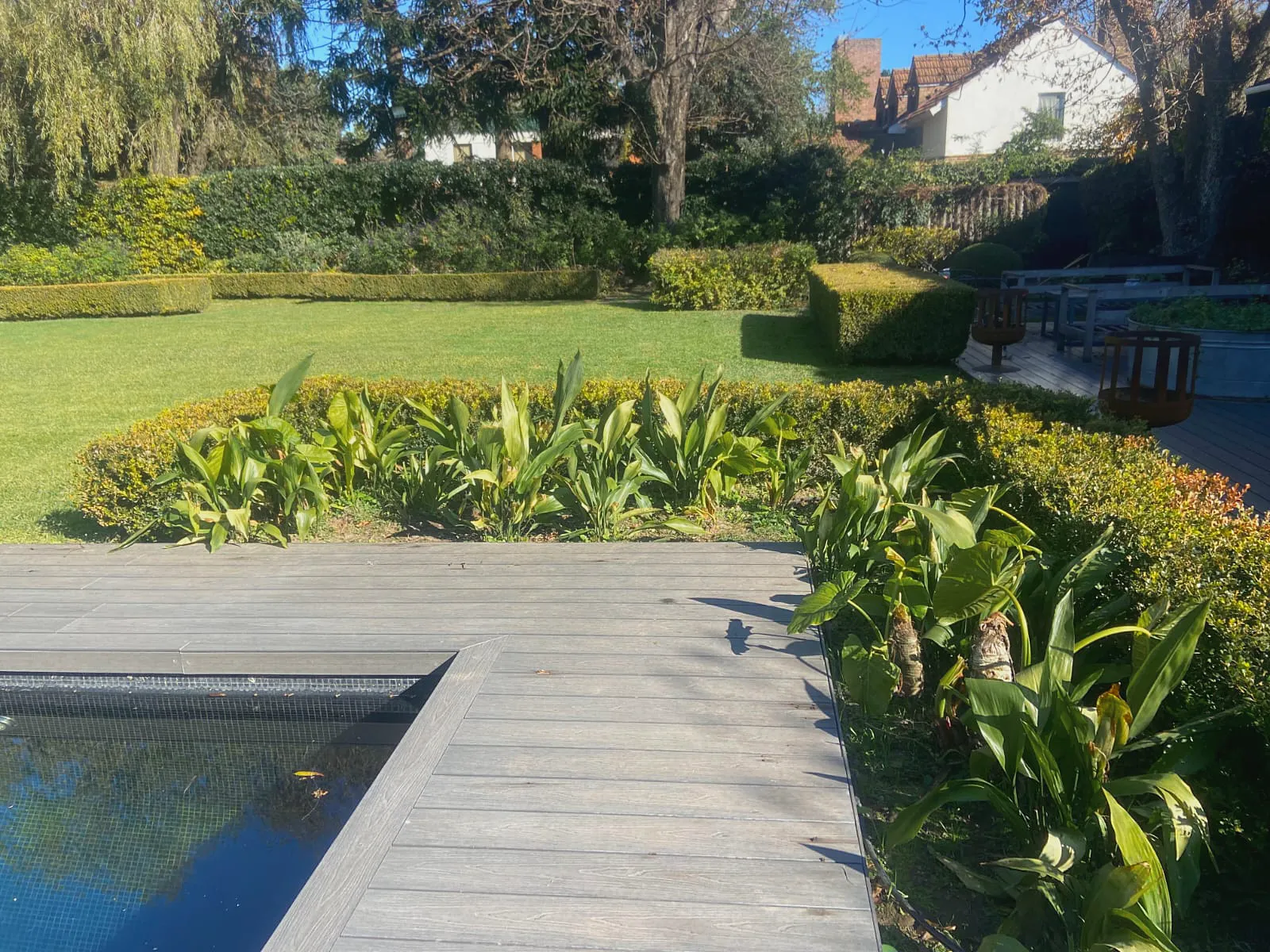Deck de madera y piscina junto al jardín